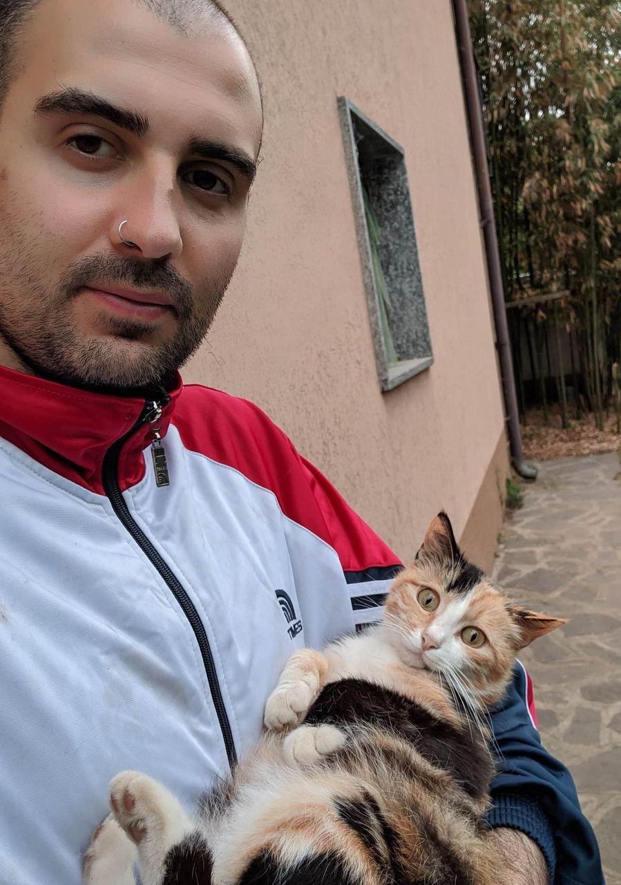 Sergio holding a female cat, Lady Grey, who is also being very cuddly